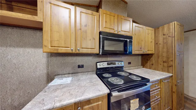a kitchen with stainless steel appliances granite countertop a stove a microwave and cabinets