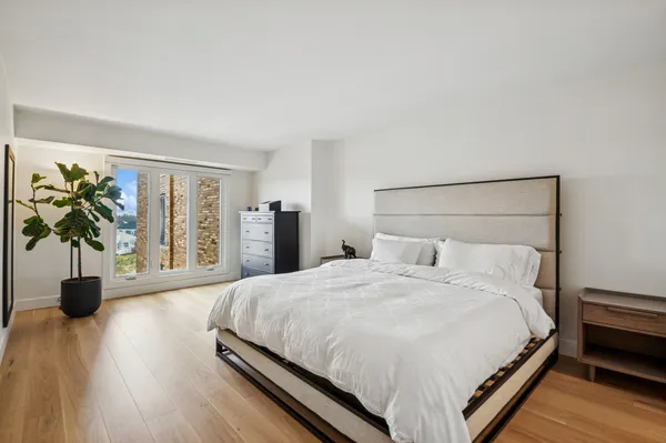 a bedroom with a bed table and a potted plant