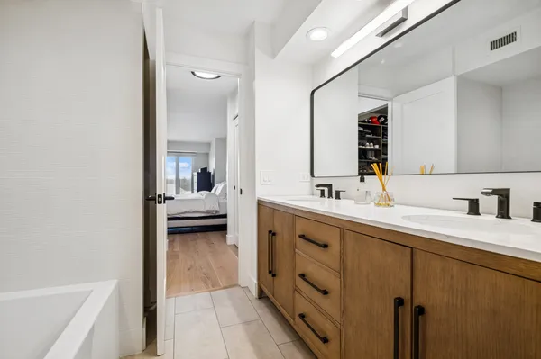 a en suite bathroom with a double vanity sink a mirror and shower