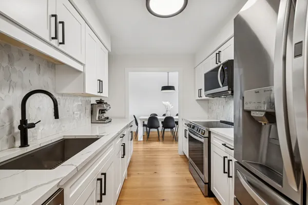 a large kitchen with stainless steel appliances granite countertop a lot of counter space and a sink