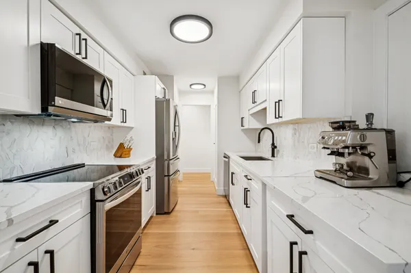 a kitchen with stainless steel appliances a sink a stove and a microwave