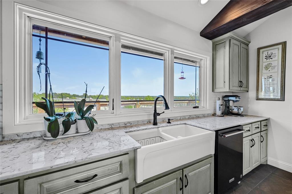 5555 County Road 179 Celina, TX 75009 - Photo 16 of 40 Kitchen with light stone counters, dishwasher, gray cabinetry, beam ceiling, and dark tile patterned floors