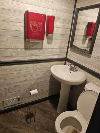 a bathroom with a toilet sink and mirror