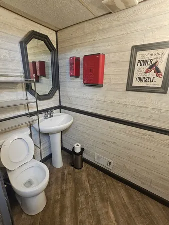 a bathroom with a toilet sink and mirror