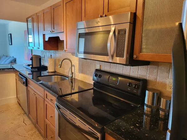 a kitchen with granite countertop a stove and a sink