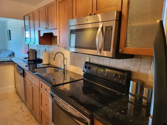 a kitchen with granite countertop a stove and a sink