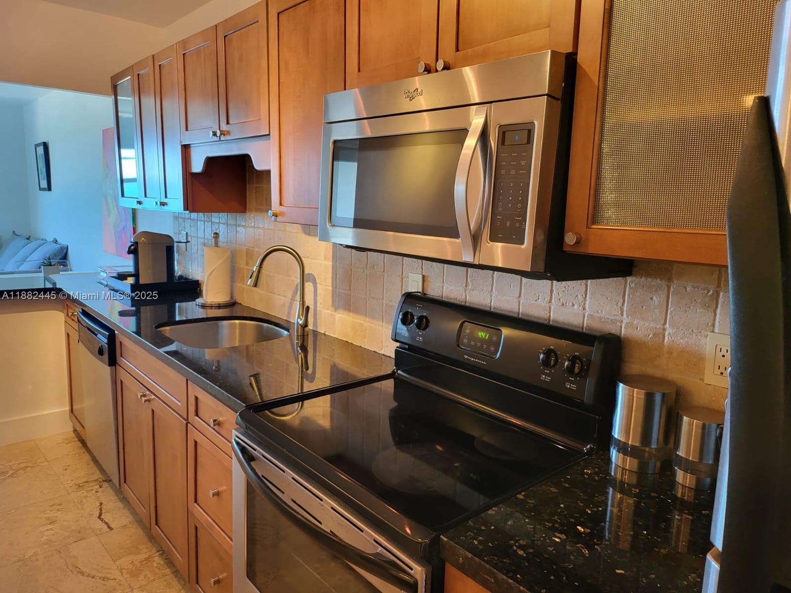 a kitchen with granite countertop a stove and a sink
