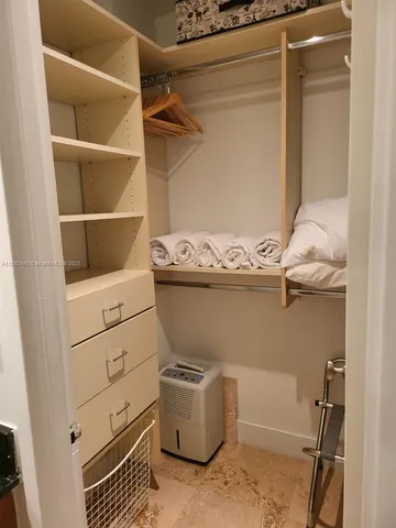 a bedroom with a bed and a lamp on dresser