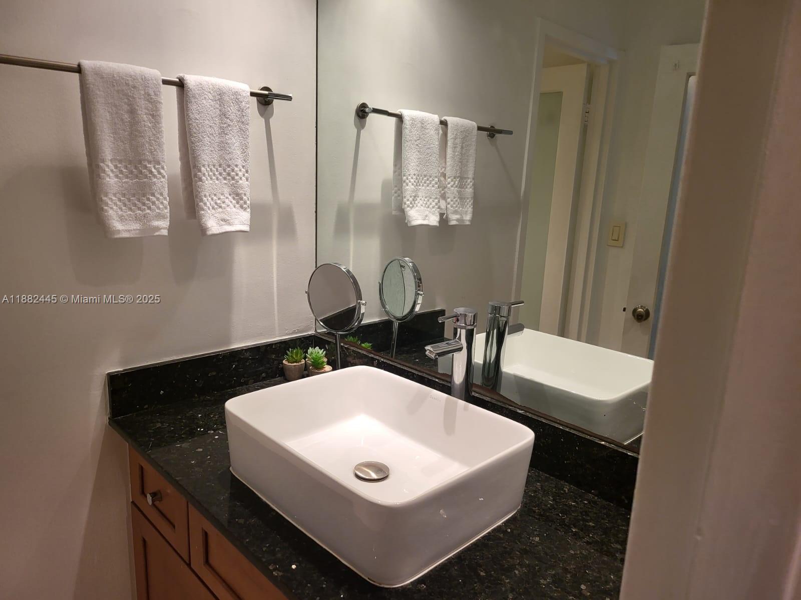 100 Lincoln Road, Unit 1238 Miami Beach, FL 33139 - Photo 20 of 31 a bathroom with a sink a toilet and a mirror
