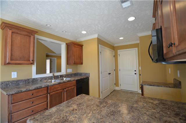 Kitchen with custom maple cabinets,pantry and tile flooring