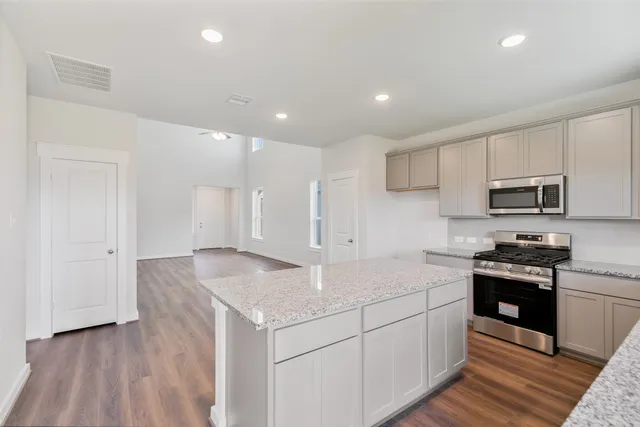 a kitchen with stainless steel appliances granite countertop a sink stove and refrigerator