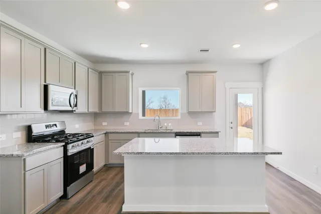 a kitchen with granite countertop white cabinets and white appliances