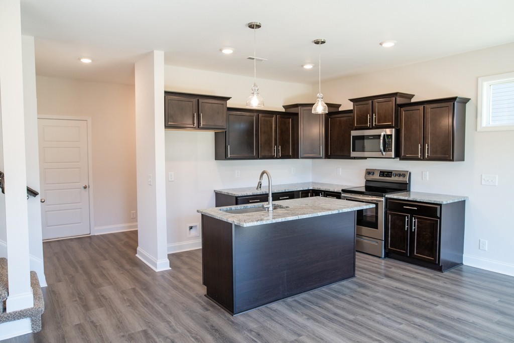 206 Copeland Road Clarksville, TN 37042 - Photo 8 of 38 a kitchen with stainless steel appliances granite countertop a stove top oven a sink dishwasher a refrigerator and a microwave oven with wooden floor