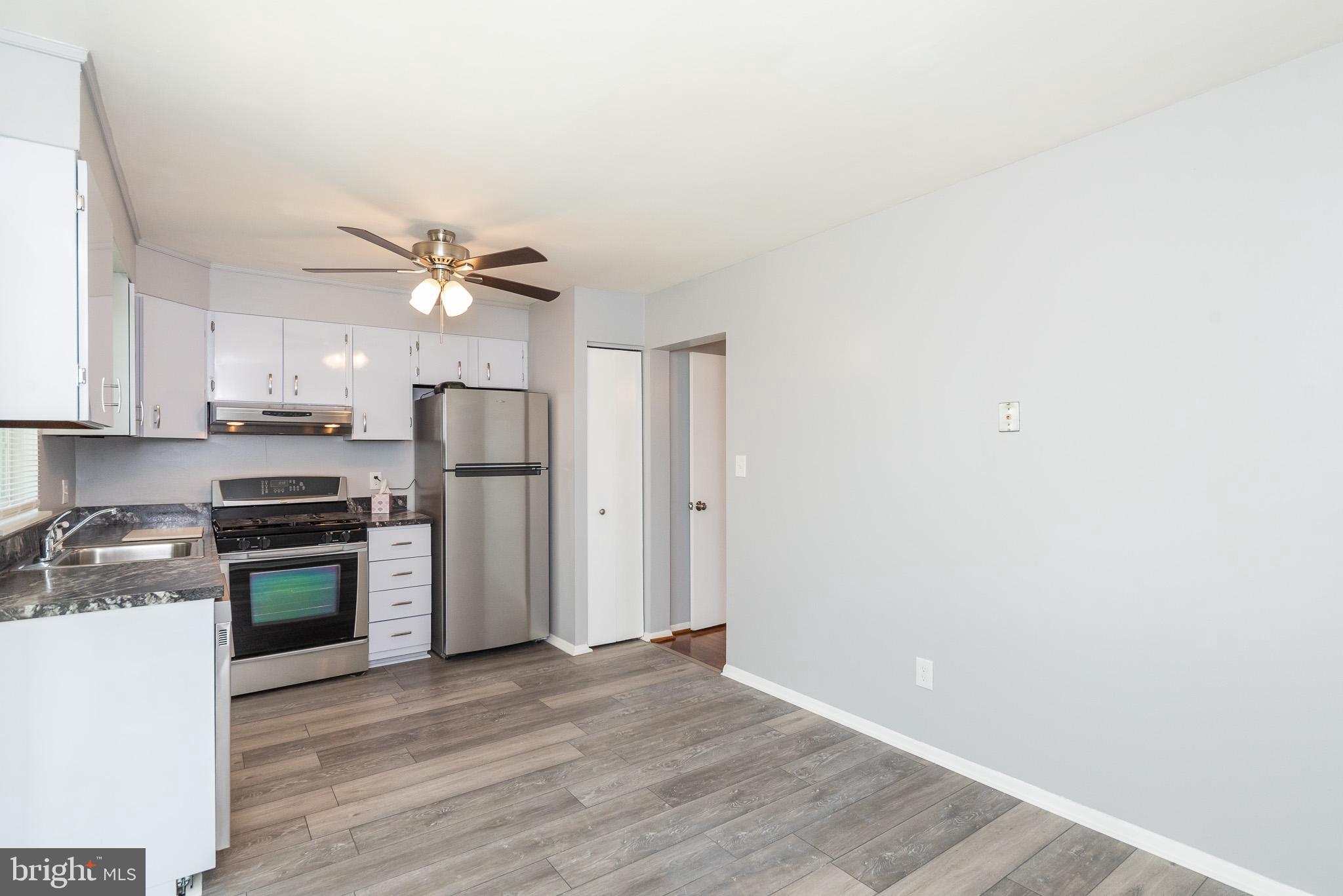 37 Cardor Court, Unit 37 Baltimore, MD 21236 - Photo 12 of 47 a kitchen with stainless steel appliances granite countertop a refrigerator a sink a stove and white cabinets with wooden floor
