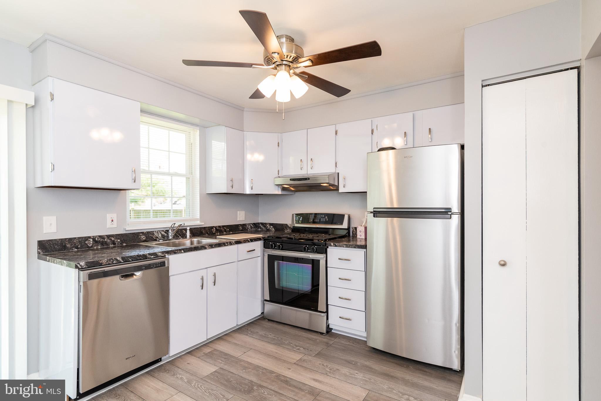 37 Cardor Court, Unit 37 Baltimore, MD 21236 - Photo 18 of 47 a kitchen with stainless steel appliances granite countertop a refrigerator a stove a sink and white cabinets with wooden floor