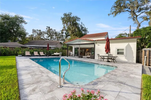 a view of a swimming pool with lawn chairs under an umbrella