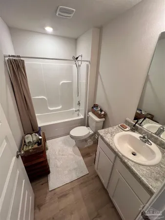 a bathroom with a sink and mirror with bathtub