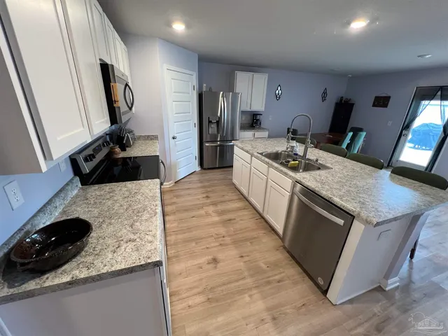 a large kitchen with a stove a sink and a refrigerator
