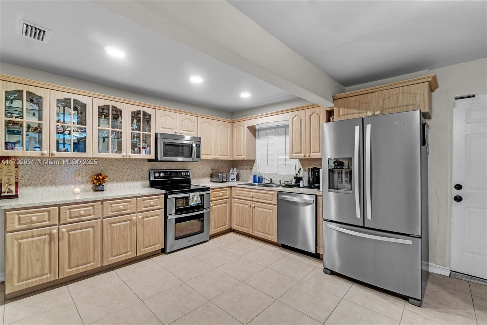 30021 Southwest 160th Avenue Homestead, FL 33033 - Photo 11 of 55 a kitchen with stainless steel appliances granite countertop a refrigerator and a stove top oven