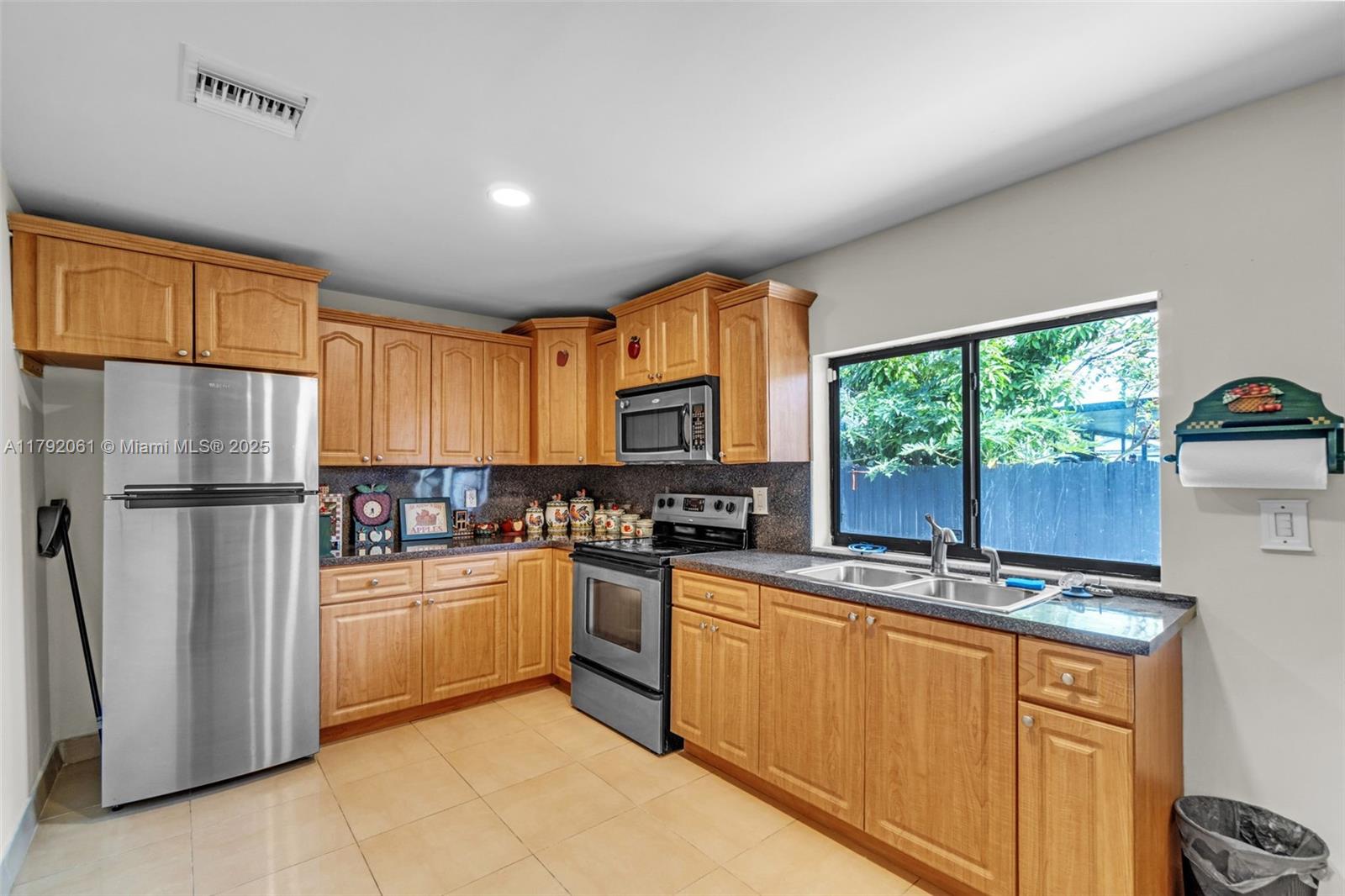 30021 Southwest 160th Avenue Homestead, FL 33033 - Photo 17 of 55 a kitchen with stainless steel appliances granite countertop a refrigerator a sink a stove a washer dryer and white cabinets