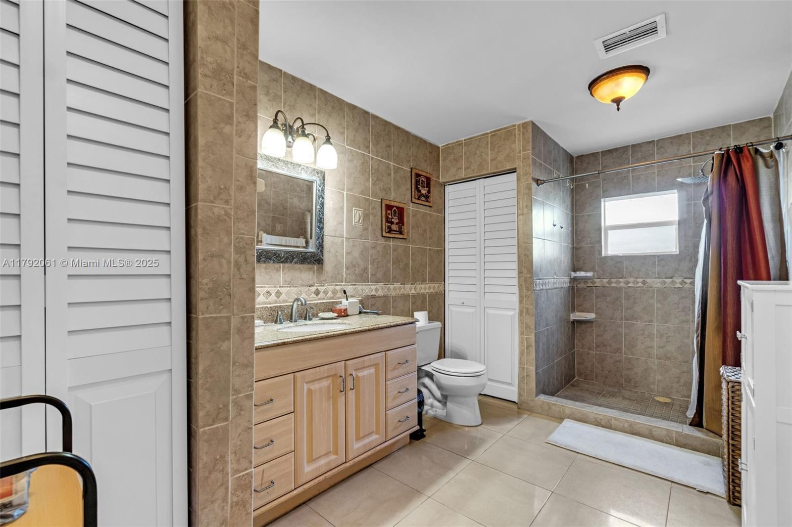30021 Southwest 160th Avenue Homestead, FL 33033 - Photo 29 of 55 a bathroom with a double vanity sink a toilet and shower