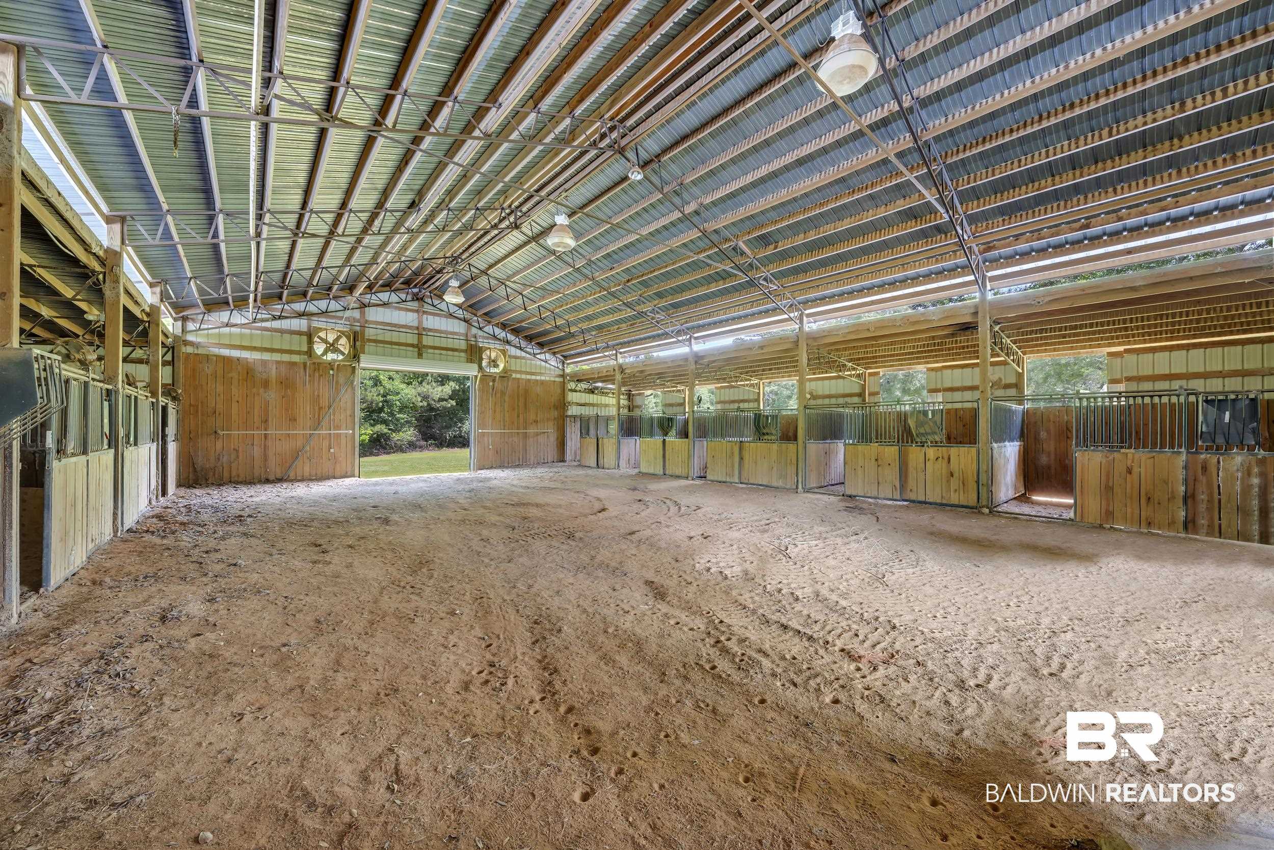 43199 Pine Grove Road Bay Minette, AL 36507 - Photo 19 of 71 Expansive barn structure with a metal roof and open-sided stalls