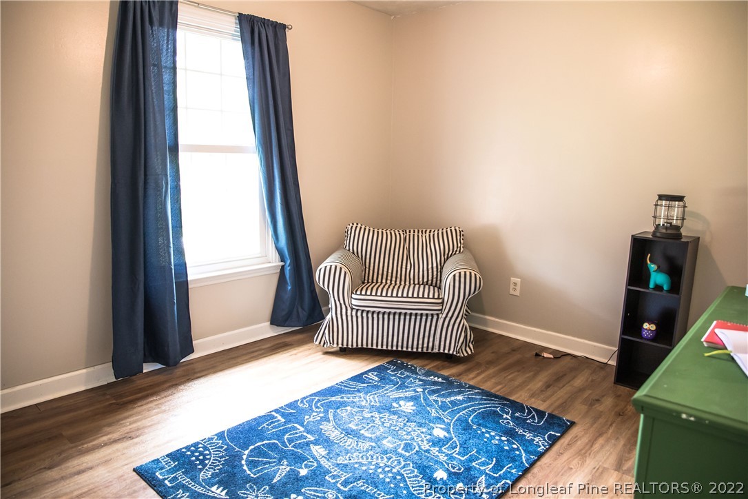 1017 Locks Creek Road Fayetteville, NC 28312 - Photo 11 of 26 an empty room with wooden floor and chair