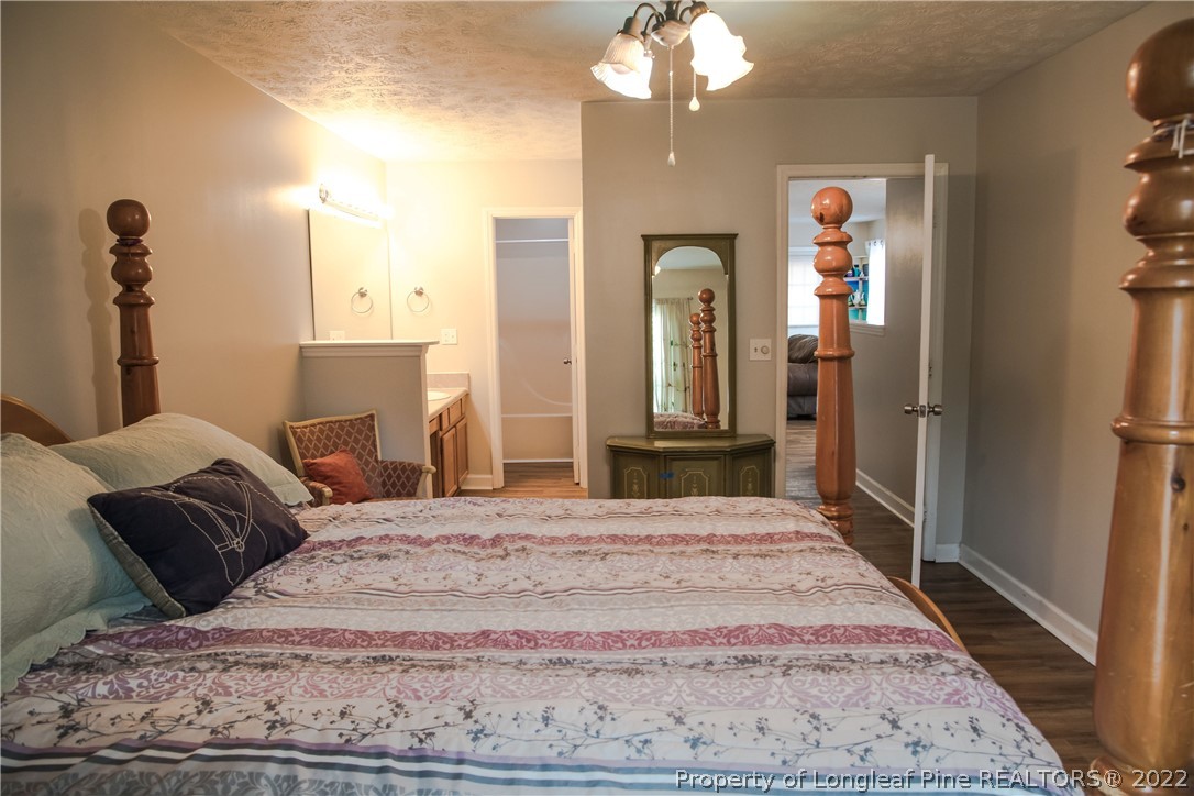 1017 Locks Creek Road Fayetteville, NC 28312 - Photo 17 of 26 a bedroom with a large bed and a chandelier