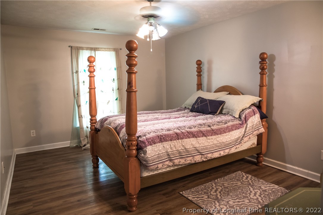 1017 Locks Creek Road Fayetteville, NC 28312 - Photo 18 of 26 a bedroom with a bed and wooden floor