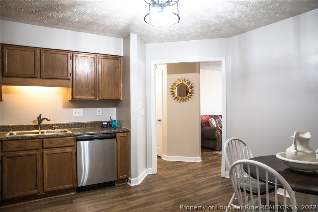 1017 Locks Creek Road Fayetteville, NC 28312 - Photo 6 of 26 a kitchen with stainless steel appliances granite countertop a refrigerator a sink a stove and island with wooden floor