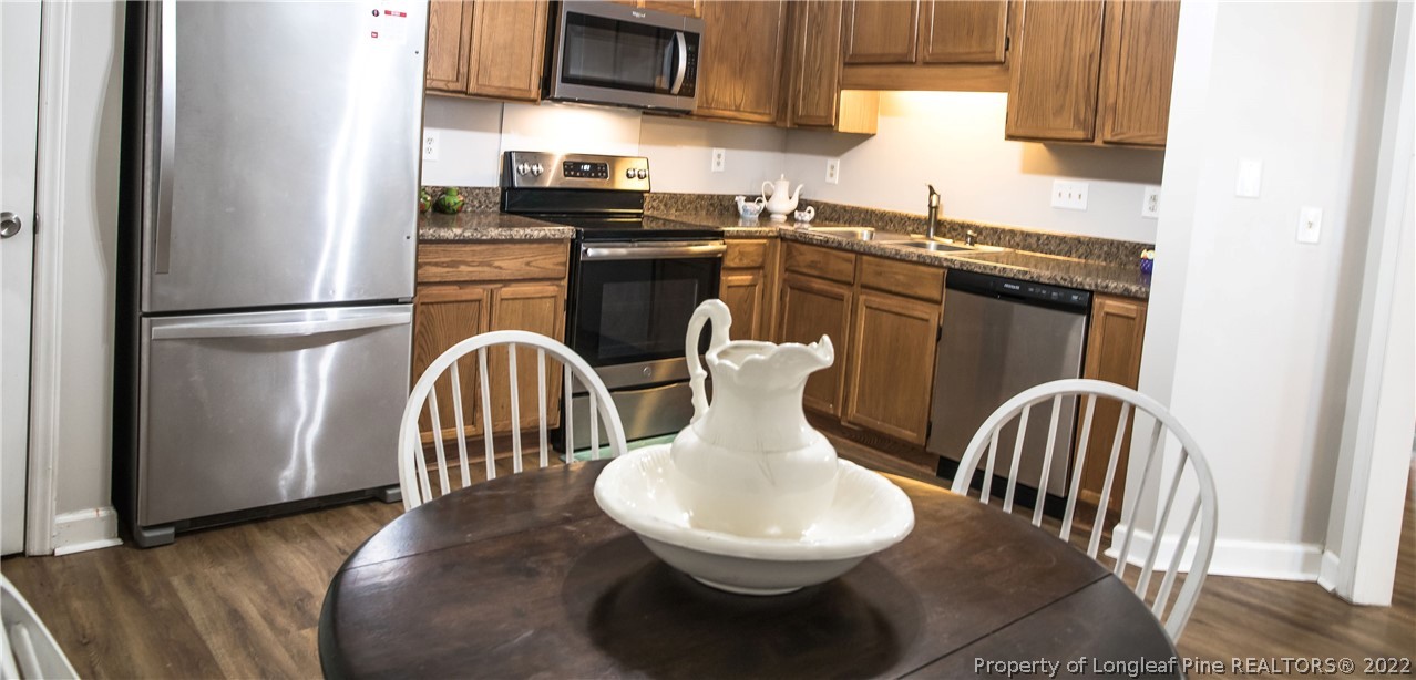 1017 Locks Creek Road Fayetteville, NC 28312 - Photo 7 of 26 a kitchen with stainless steel appliances granite countertop a refrigerator a stove a sink dishwasher and microwave with wooden floor