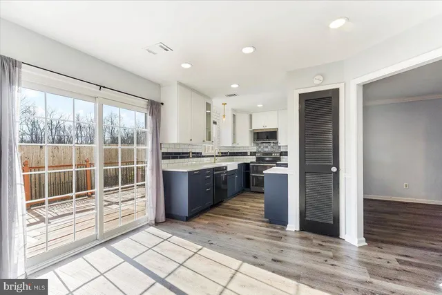a large kitchen with a window and stainless steel appliances