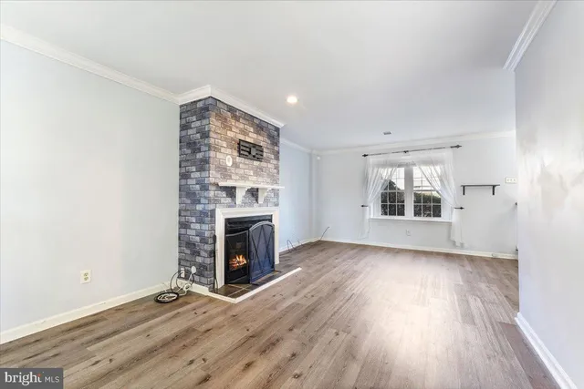 an empty room with windows and fireplace