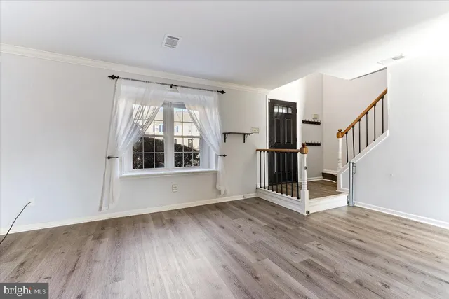 wooden floor in an empty room with a window