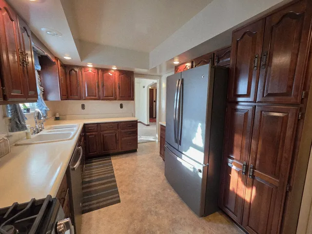 a kitchen with stainless steel appliances granite countertop a refrigerator and a sink