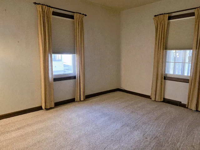 an empty room with windows and closet
