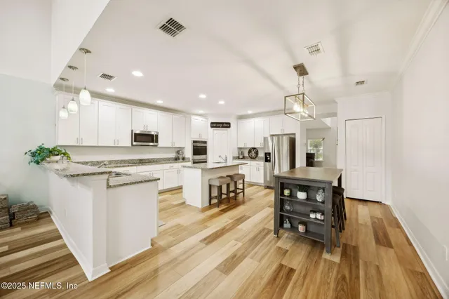 a kitchen with granite countertop white cabinets and stainless steel appliances