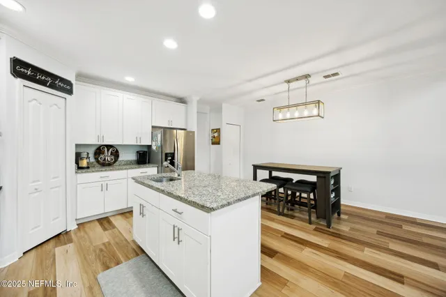 a kitchen with white cabinets and stainless steel appliances