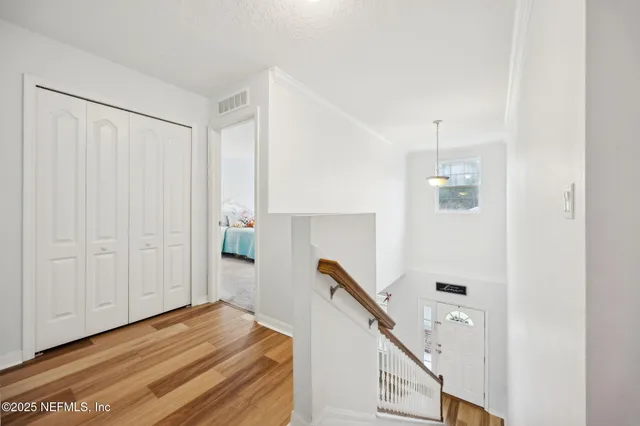 a view of a hallway with wooden floor and windows