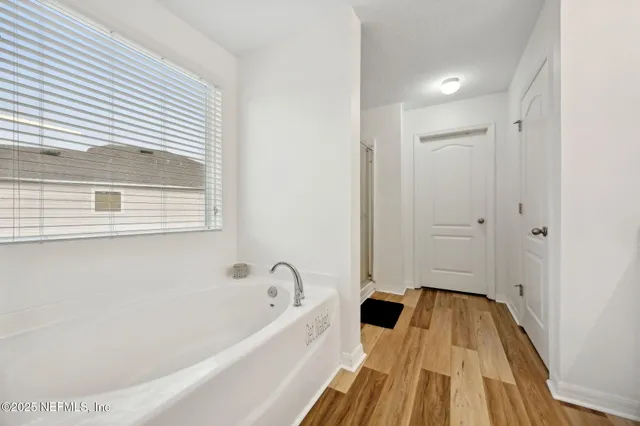 a bedroom with a bed and a dresser with mirror