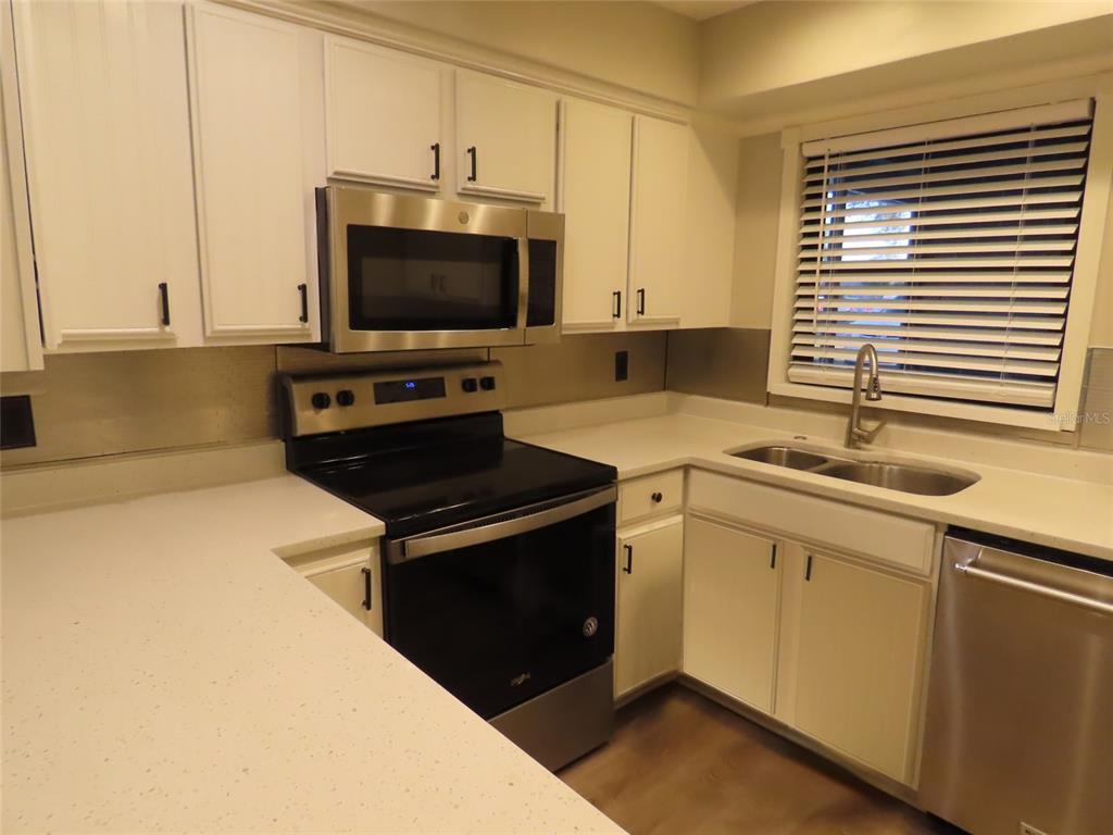 1798 Faulds Road North Clearwater, FL 33756 - Photo 11 of 34 a kitchen with stainless steel appliances a stove microwave and sink