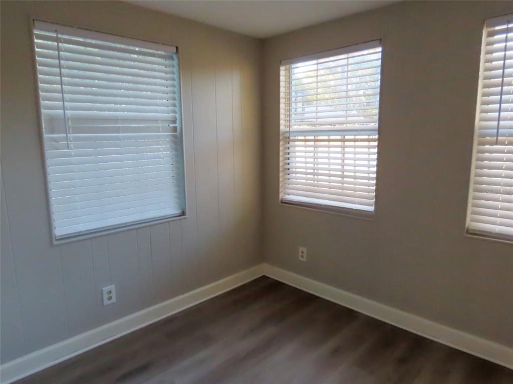 1798 Faulds Road North Clearwater, FL 33756 - Photo 13 of 34 a view of an empty room with wooden floor and a window