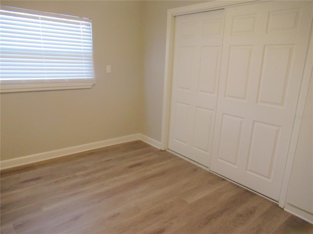 1798 Faulds Road North Clearwater, FL 33756 - Photo 14 of 34 an empty room with wooden floor and windows
