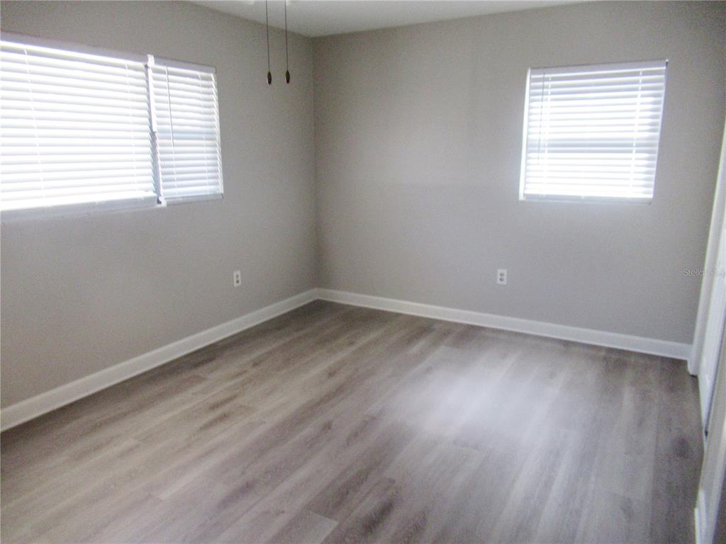 1798 Faulds Road North Clearwater, FL 33756 - Photo 18 of 34 an empty room with wooden floor and windows