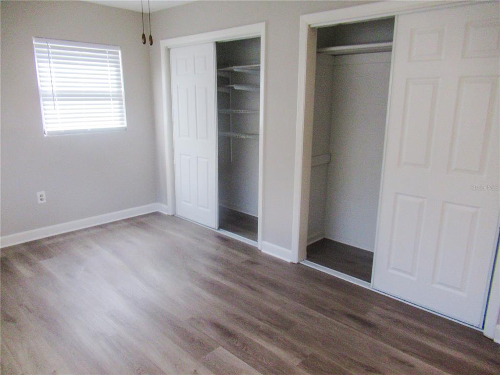 1798 Faulds Road North Clearwater, FL 33756 - Photo 19 of 34 an empty room with wooden floor and windows