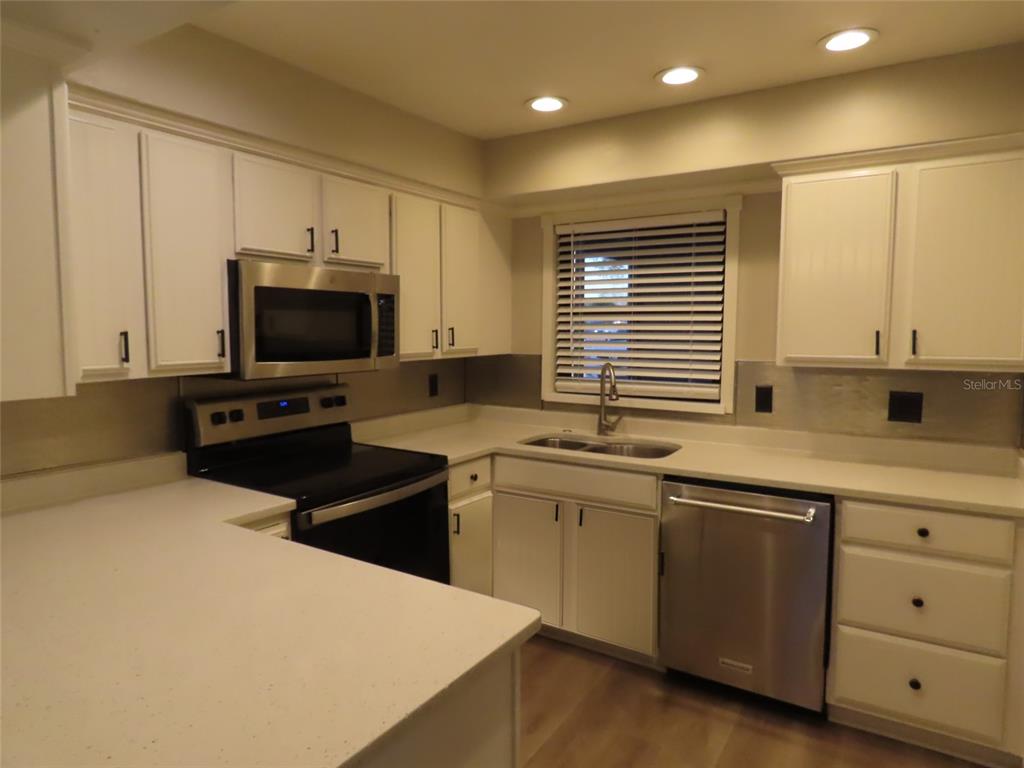 1798 Faulds Road North Clearwater, FL 33756 - Photo 10 of 34 a kitchen with stainless steel appliances a stove sink and microwave