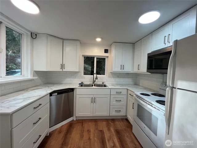 a kitchen with a sink stove cabinets and refrigerator
