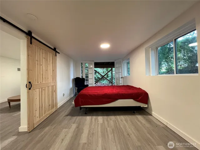 a living room with a balcony a bed furniture and a window