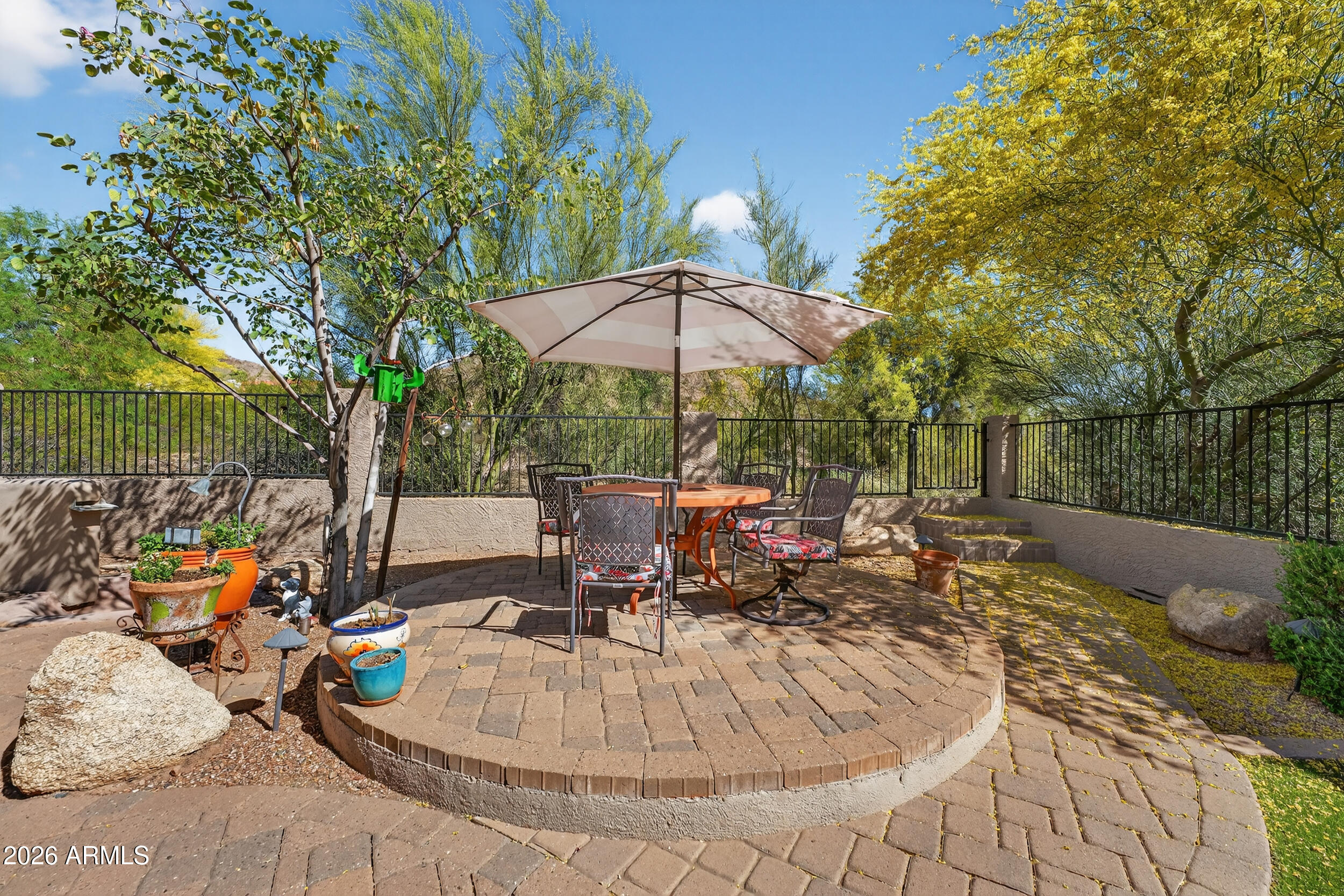 1539 East Winged Foot Road Phoenix, AZ 85022 - Photo 58 of 64 a view of a patio with furniture and a table and chairs under an umbrella