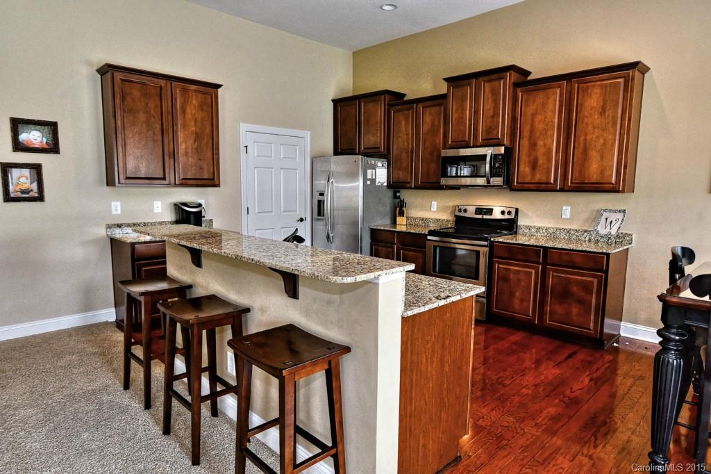 1628 Ridgehaven Road Waxhaw, NC 28173 - Photo 7 of 24 a kitchen with stainless steel appliances a sink a stove a refrigerator cabinets and dining table